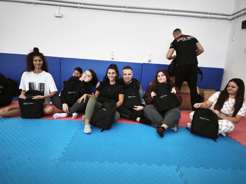 Участници в обучение по самозащита практикуват техники в спортна зала./Participants in a self-defense training practice techniques in a gym