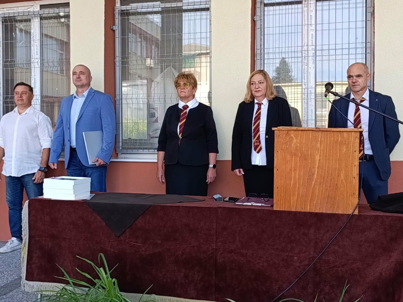 Представители на академичната общност стоят пред трибуна по време на тържествено откриване на учебната година