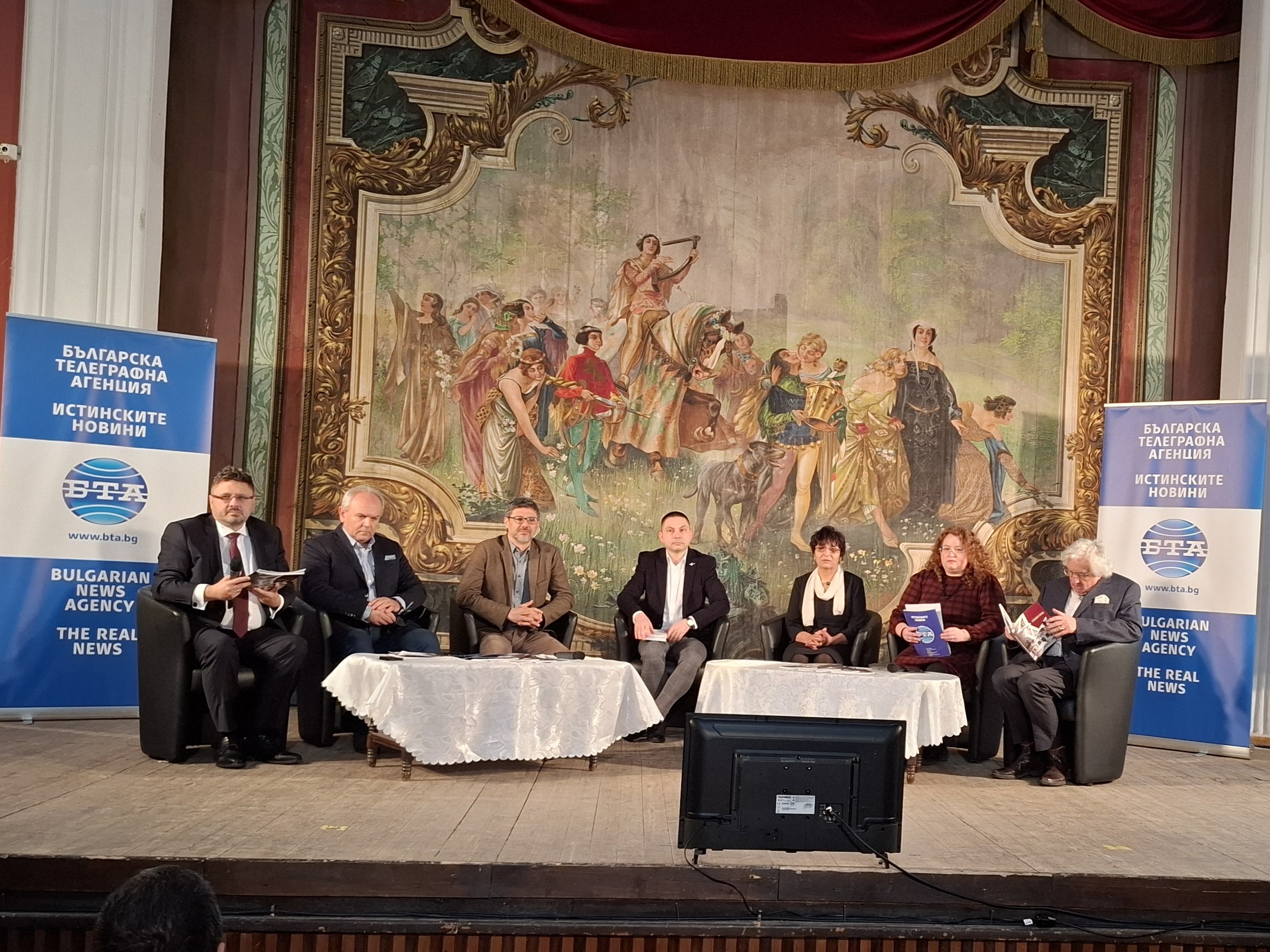 Кирил Вълчев говори на пресконференцията за представянето на списание ЛИК в Свищов на заден план са микрофони и телевизор.