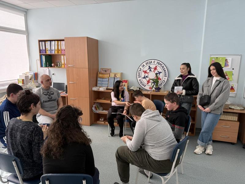 Председателят на Студентския съвет и първокурсничка разговарят с деца в Дневния център за деца с увреждания по време на дарителската акция