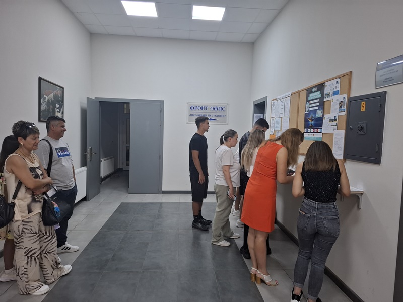 Кандидат-студенти разглеждат информацията за прием в коридор на Стопанска академия „Димитър А. Ценов“