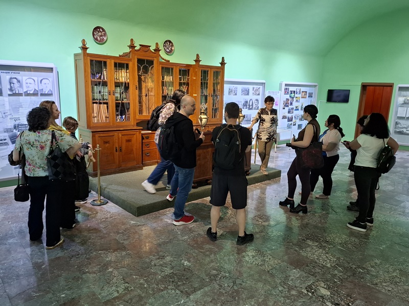 Журналисти от БТА разглеждат витрина с награди и почетни грамоти в Академията