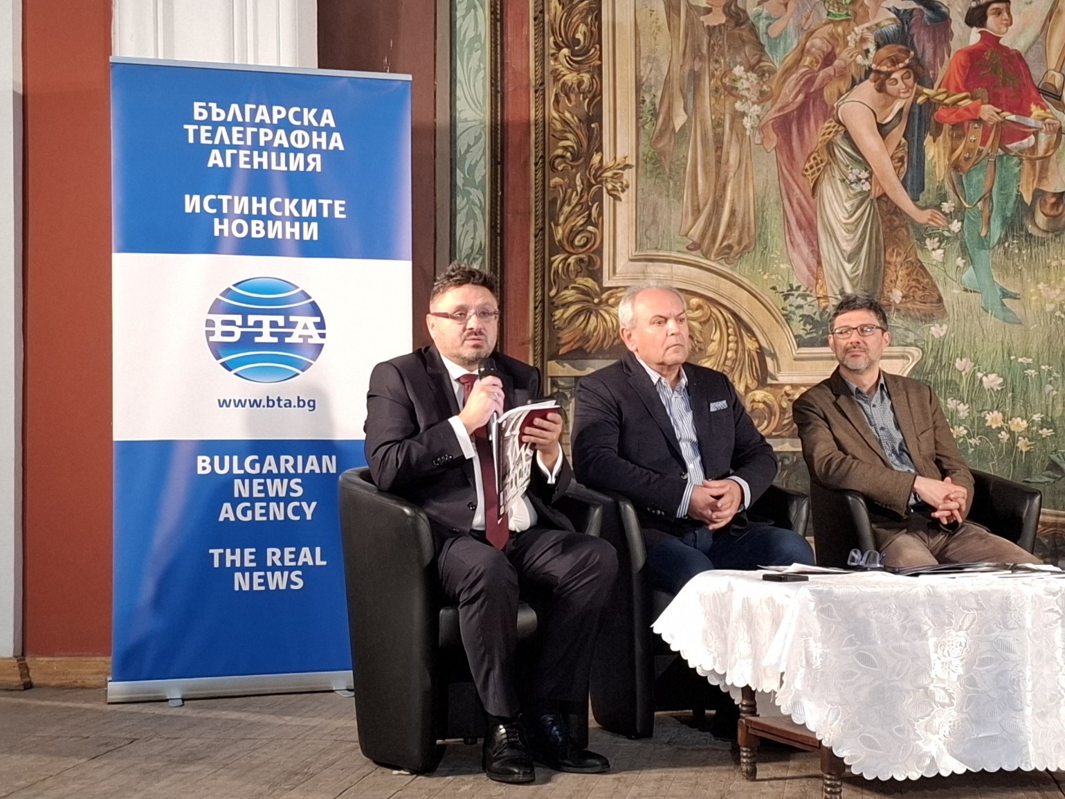 Кирил Вълчев главен редактор на списание ЛИК доц. Георги Лозанов и Яница Христова по време на дискусията за читалищното дело в Свищов банер на БТА на заден план.