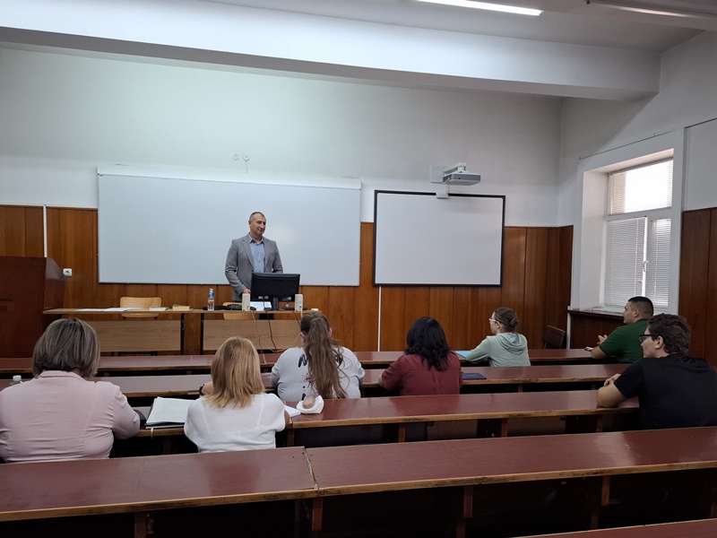 Преподавател изнася лекция пред студенти в голяма аудитория в Стопанска академия „Димитър А. Ценов