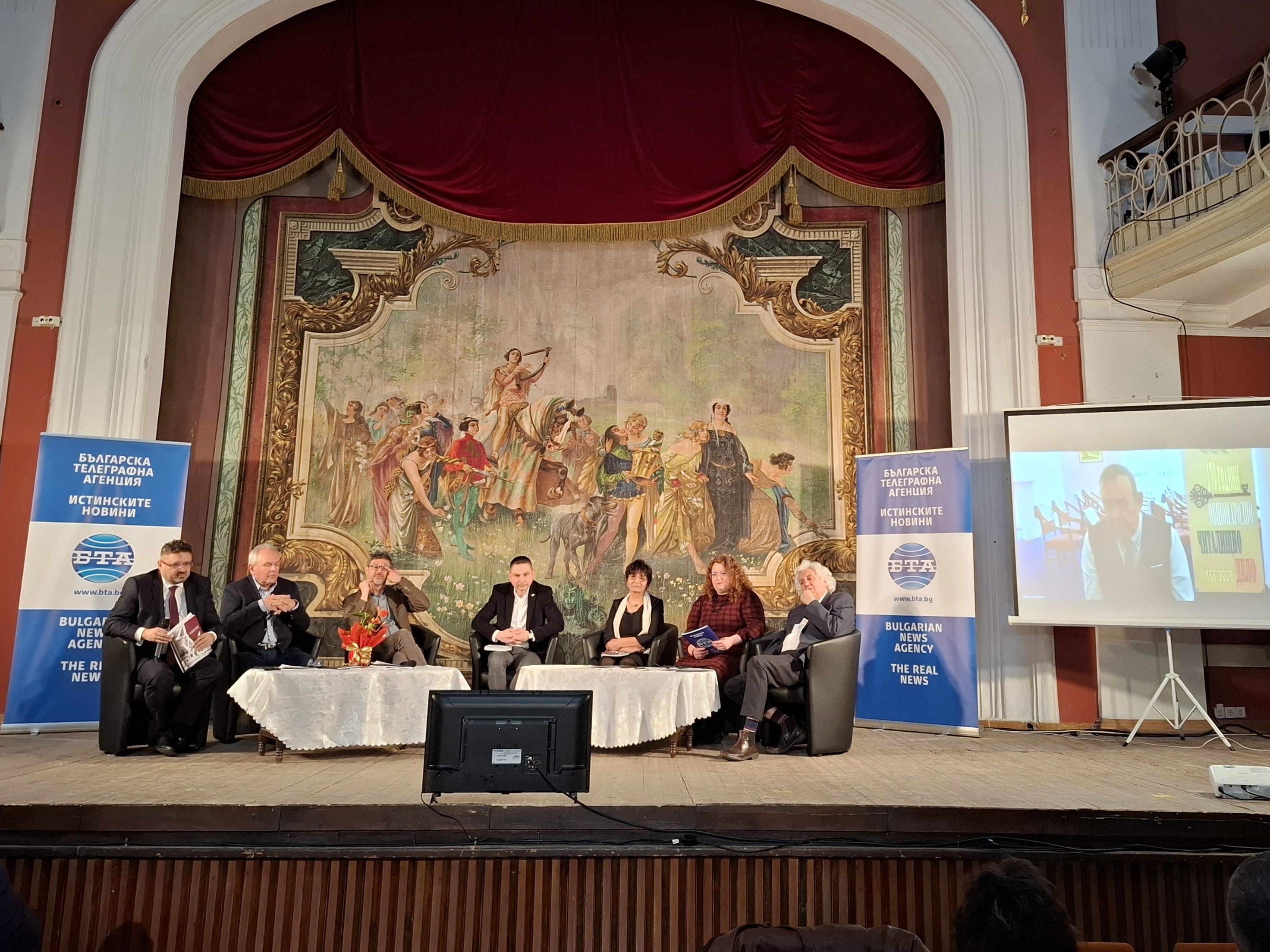 Участници в дискусията за 170-годишнината на читалищното дело в Свищов седнали зад маса на сцената.