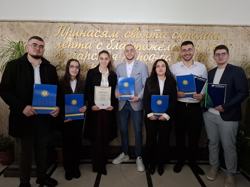 Наградените студенти позират за снимка пред стена с надпис