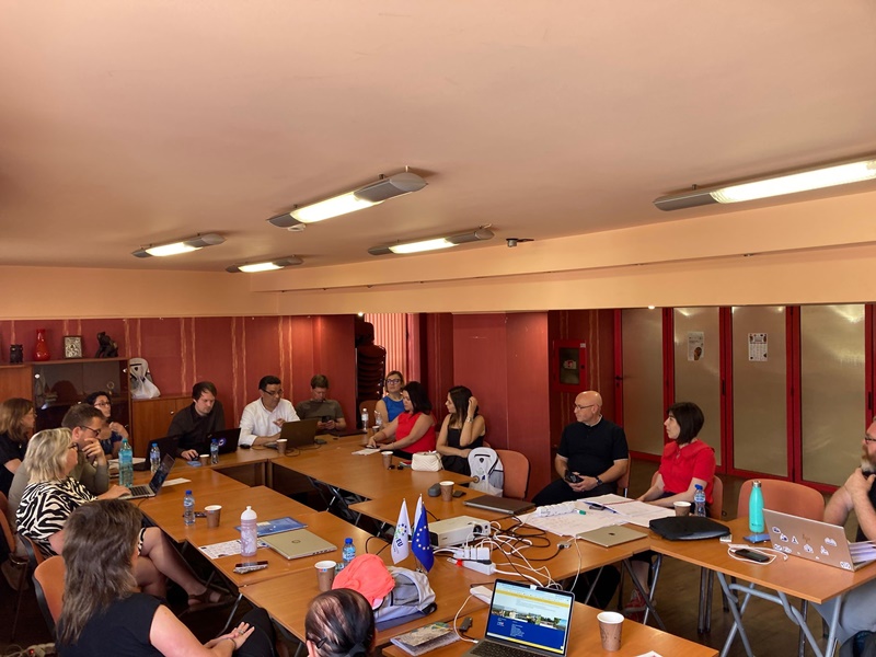 A group of people sitting at a table with laptops