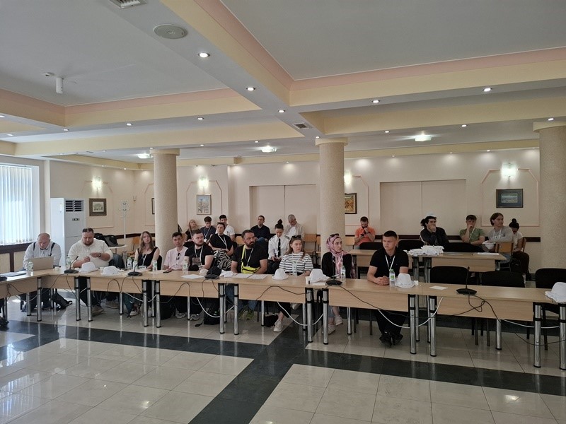 A group of people sitting at tables in a room AI-generated content may be incorrect.